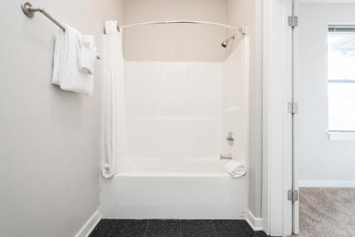 a white bathroom with a shower and a sink at CozySuites Music Row Elegant 1BR w free parking 51 in Nashville