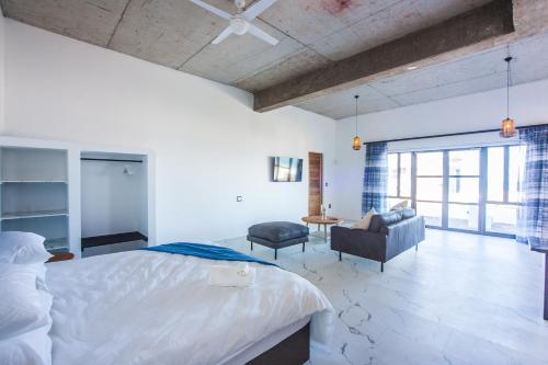 a bedroom with a bed and a chair and a couch at Yzerfontein Villa Fantastica - No Loadshedding in Yzerfontein