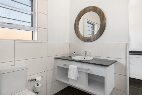 a white bathroom with a sink and a mirror at Park Hotel Mokopane in Mokopane