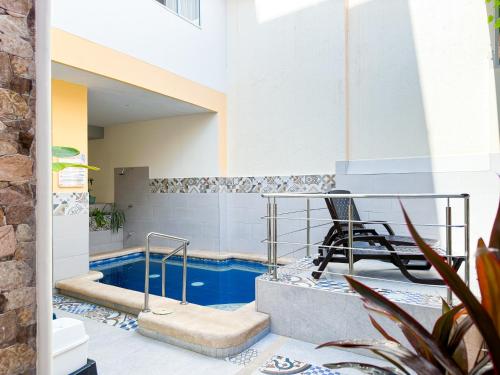 a pool with a table and a chair on a patio at Hotel Zamay Centro Historico in Santa Marta