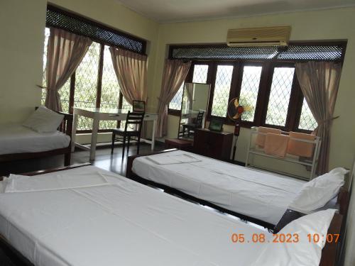 a bedroom with two beds and a mirror at Serenity in Kandy