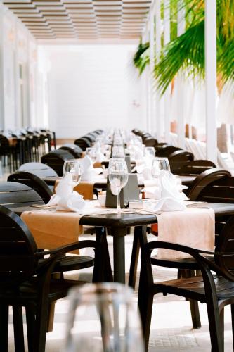 a long row of tables and chairs with wine glasses at Oz Hotels Sui in Alanya