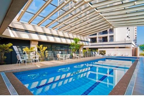 a swimming pool with a glass ceiling and a building at Nobile Congonhas in São Paulo