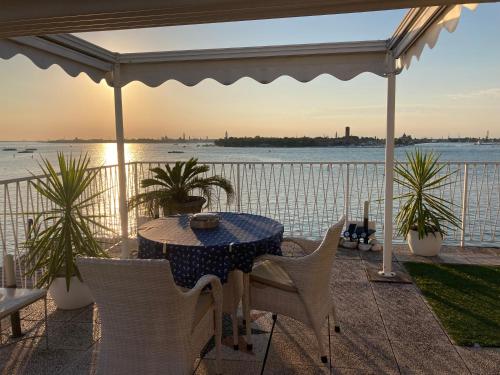 a table and chairs on a patio with a view of the water at OASIS Golden Lagoon Chalet in Venice-Lido