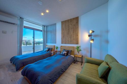 um quarto amplo com 2 camas e um sofá em Kunigami-gun - House / Vacation STAY 47662 em Onna