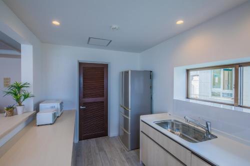 uma cozinha com um lavatório e um frigorífico em Kunigami-gun - House / Vacation STAY 47662 em Onna
