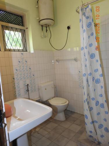 La salle de bains est pourvue de toilettes, d'une baignoire et d'un lavabo. dans l'établissement Serenity, à Kandy