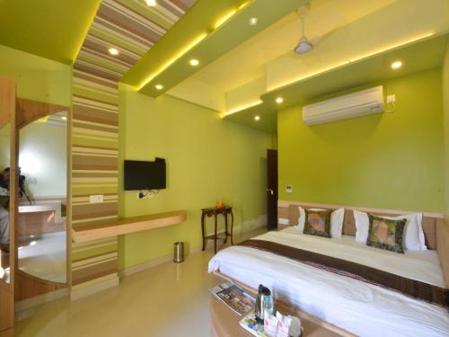 a hotel room with a bed and a tv at Hotel Banaras Haveli in Varanasi