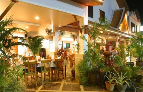 un restaurant avec une table, des chaises et des plantes dans l'établissement Kamala Dreams, à Kamala Beach