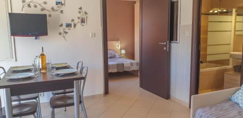 une chambre avec une table et une chambre avec un lit dans l'établissement Joli appartement en Corse avec piscine, à Belgodère