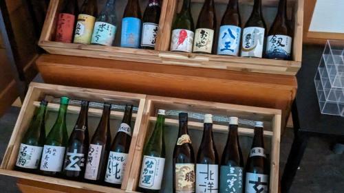 a bunch of wine bottles in a wooden box at Tonamino Shogawaso Ichimantei in Tonami