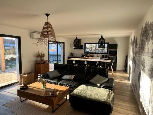 un salon avec un canapé et une table dans l'établissement Maison neuve proche de l'Océan et au calme, à Mimizan