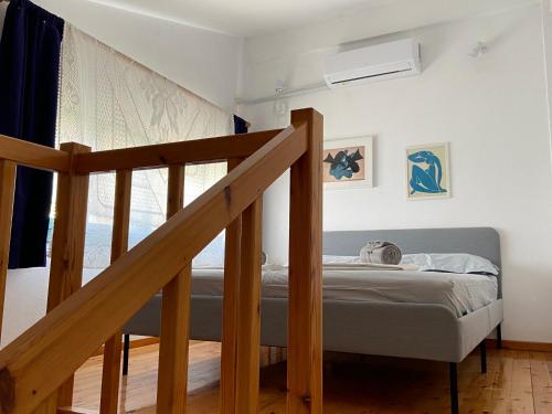 a small bedroom with a bed and a staircase at Pinelopi Holiday House in Melínta