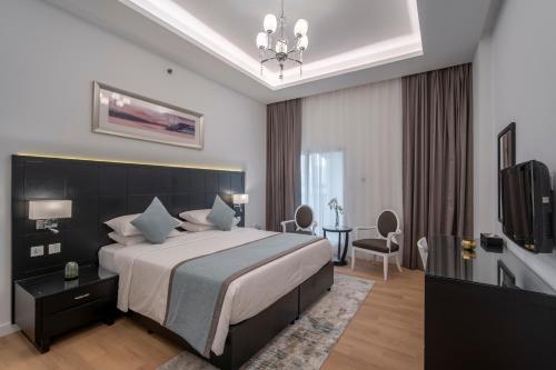 Rose Garden Hotel Apartments - Al Barsha, Near Metro Station في دبي: غرفه فندقيه سرير وتلفزيون