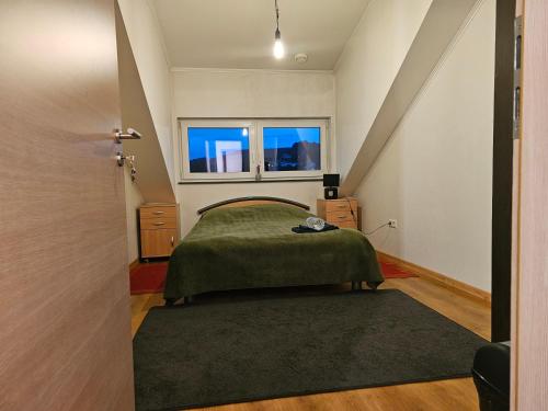 Schlafzimmer mit einem Bett und einem Fenster in der Unterkunft Chambre privé dans belle maison 2 in Ettelbruck