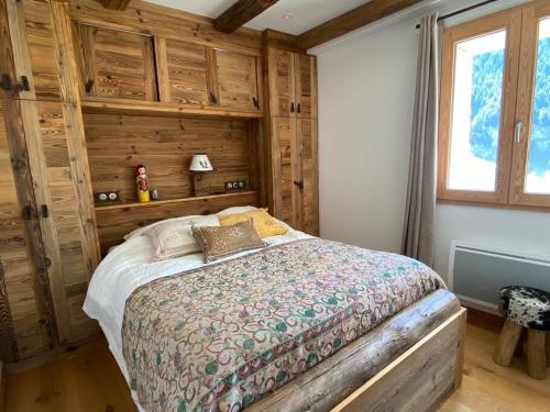 um quarto com uma cama num quarto com paredes de madeira em Chalet de charme 190m2, La Lauzière, ski à pieds em Peisey-Nancroix