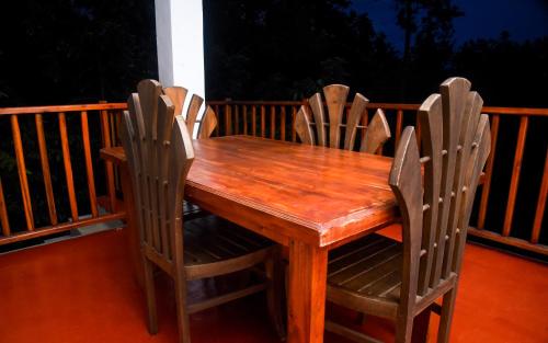 a wooden table and chairs on a porch at Eco Diamond Palace in Ella
