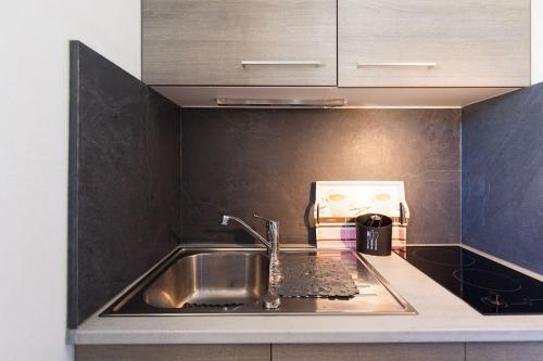 un comptoir de cuisine avec un évier et un micro-ondes dans l'établissement Terrasse et vue mer sur la baie de Cannes, au Cannet