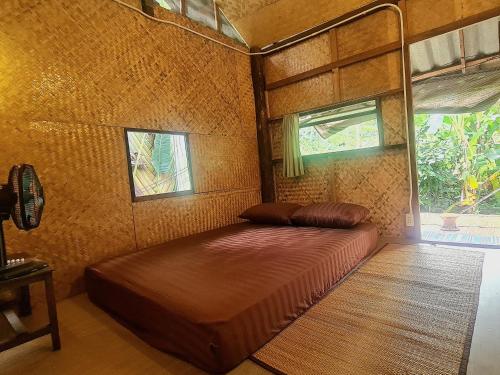 a bedroom with a bed in a room with a window at Sun Moon Pai Bungalow in Pai