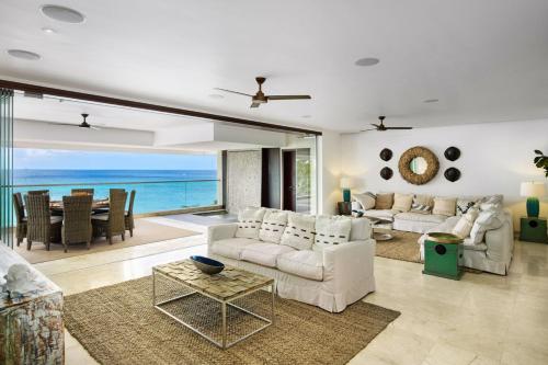 Una sala de estar con muebles blancos y vista al mar. en Portico 3 by Blue Sky Luxury, en Saint James