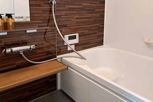eine Badewanne mit einem Schlauch, der an ein Waschbecken angeschlossen ist in der Unterkunft ホリデーハウス慈野(ジノ) in Takayama