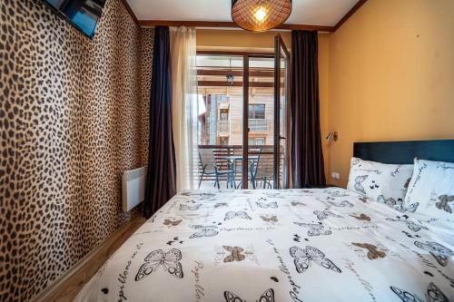 a bedroom with a large bed and a balcony at Peaceful Bansko Hideout in Bansko