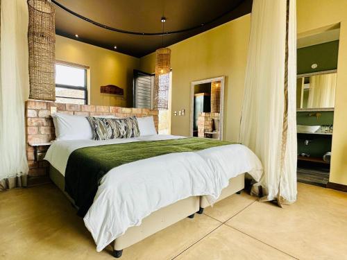 a bedroom with a large bed in a room at Lodge Damaraland in Khorixas