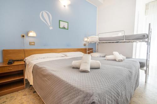 a bedroom with two beds with towels on them at Hotel Santiago in Rimini