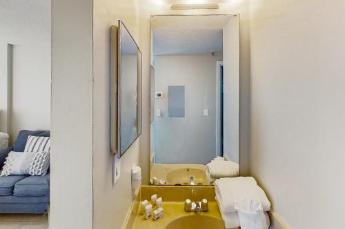 a bathroom with a yellow sink and a mirror at Renaissance 908 in Myrtle Beach