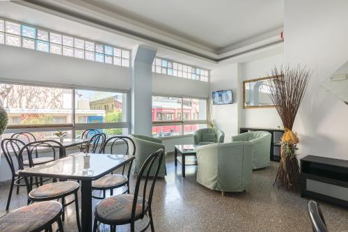 a restaurant with tables and chairs and windows at Hotel Santiago in Rimini