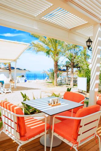 a patio with a table and chairs and the ocean at Oz Hotels Sui in Alanya