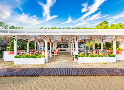 a pavilion with tables and chairs on the beach at Oz Hotels Sui in Alanya