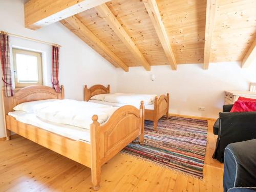 two beds in a room with wooden ceilings at Chalet Hochkrimml with sauna on the ski slope in Nothdorf