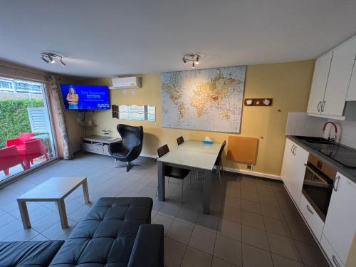 a kitchen and living room with a table and a couch at Prinses Elisabeth in Koksijde
