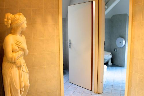 Una statua di una donna in piedi in un bagno di Le Cénacle a Ginevra