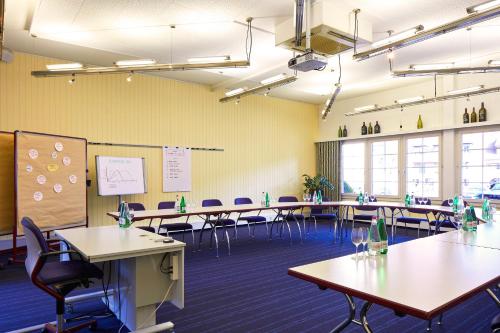 a classroom with tables and chairs in a room with yellow walls at Hirschen Erlinsbach Swiss Quality in Erlinsbach