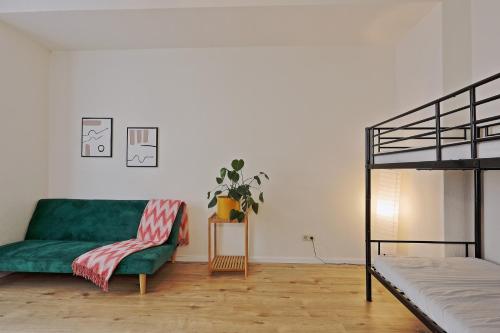 a living room with a green couch and a bed at NEXT HOME - FREE Parking & WiFi - Badewanne in Duisburg
