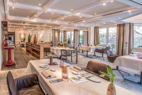 ein Restaurant mit Tischen, Stühlen und Fenstern in der Unterkunft Landhotel Hirschen Swiss Quality in Aarau