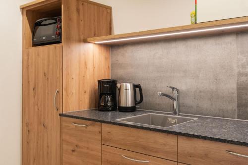 a kitchen with a sink and a coffee maker at App Mittermairhof in Riscone
