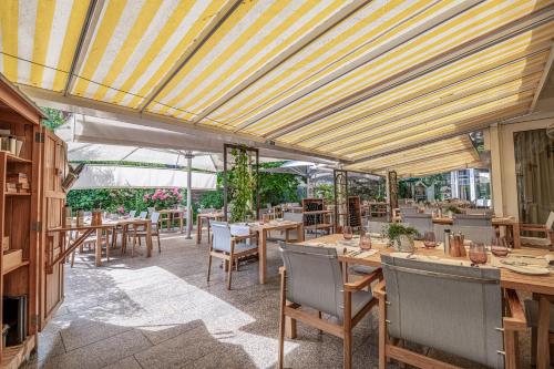 a restaurant with tables and chairs and awnings at Hirschen Erlinsbach Swiss Quality in Erlinsbach