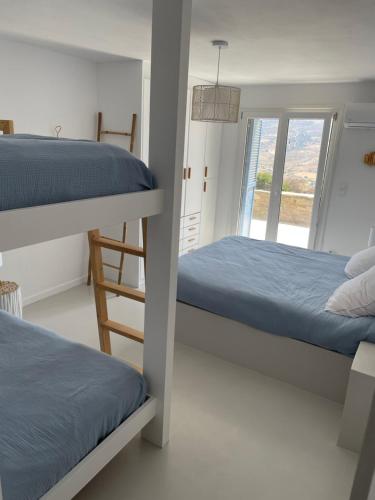 a bedroom with two bunk beds and a window at VIlla Gorgona, maison cycladique in Gavrion