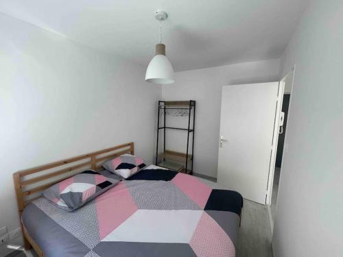 - une chambre avec un lit et une couverture colorée dans l'établissement T2 Neuf en plein cœur de Rennes au bord de la vilaine, à Rennes
