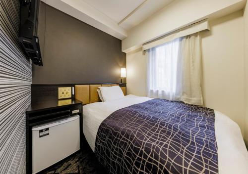 福岡市にあるアパホテル博多駅前4丁目のベッドとテレビが備わるホテルルームです。