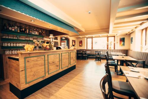 a restaurant with tables and chairs and a bar at Hotel & Restaurant Hubertus Sehnde in Sehnde