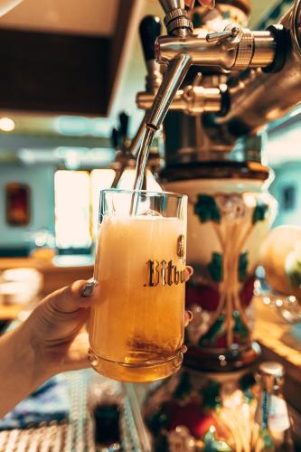 a person is holding a glass of beer at Hotel & Restaurant Hubertus Sehnde in Sehnde