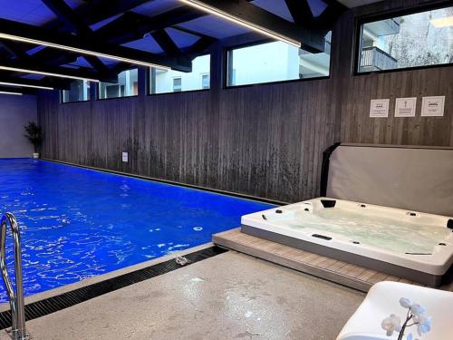 a large swimming pool with a tub in a room at Top Floor Apartment Årossanden 5 A in Kristiansand