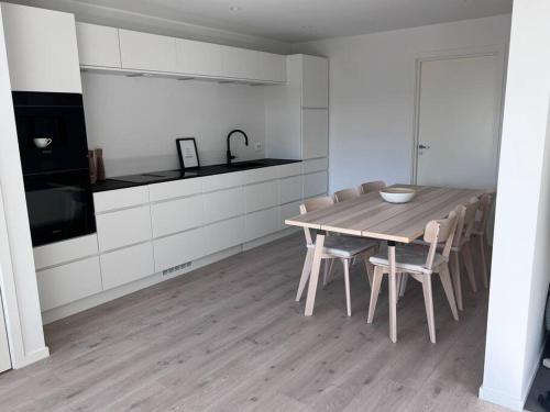 a kitchen with a wooden table and chairs at Top Floor Apartment Årossanden 5 A in Kristiansand