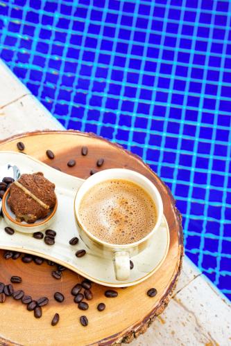 a cup of coffee and a piece of cake on a tray at Oz Hotels Sui in Alanya