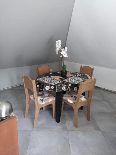 a table and chairs with a vase with flowers on it at Chez Claudia in Salazie