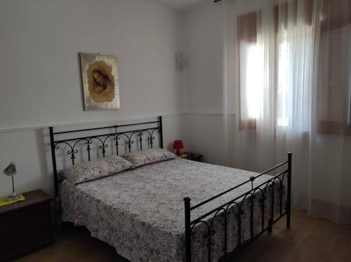 um quarto com uma cama e uma janela em Villetta La Melissa em Cutrofiano